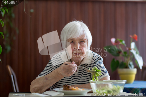 Image of Solitary senior woman eating her lunch at retirement home.