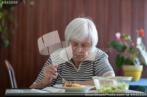 Image of Solitary senior woman eating her lunch at retirement home.