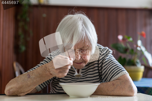 Image of Solitary senior woman eating her lunch at retirement home.