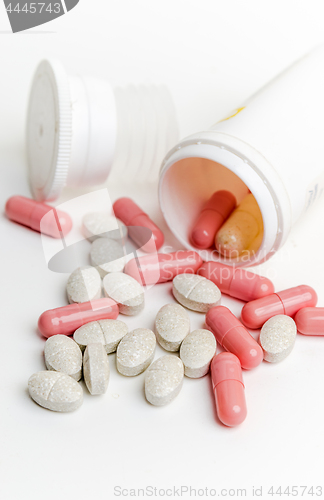 Image of Pills and capsules in a jar on a white background