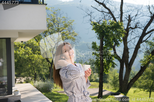 Image of woman in a bathrobe enjoying morning coffee