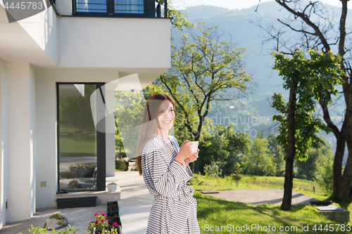 Image of woman in a bathrobe enjoying morning coffee