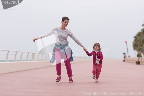 Image of mother and cute little girl on the promenade by the sea