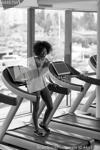 Image of afro american woman running on a treadmill