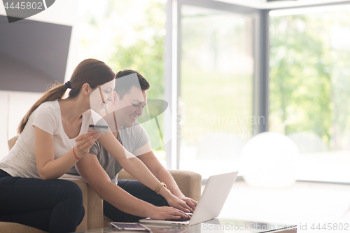 Image of happy young couple buying online