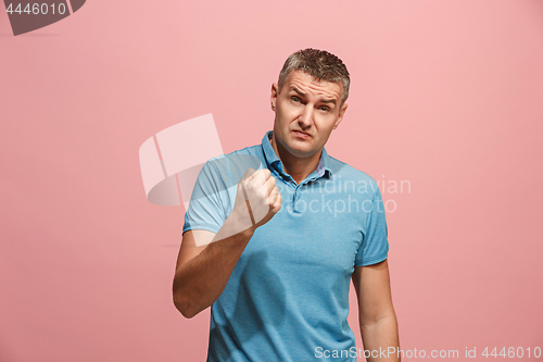 Image of Beautiful male half-length portrait isolated on pink studio backgroud. The young emotional surprised man