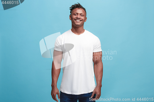 Image of The happy afro-american business man standing and smiling against blue background.