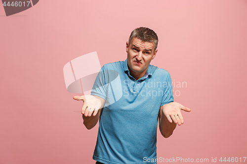 Image of Beautiful male half-length portrait isolated on pink studio backgroud. The young emotional surprised man