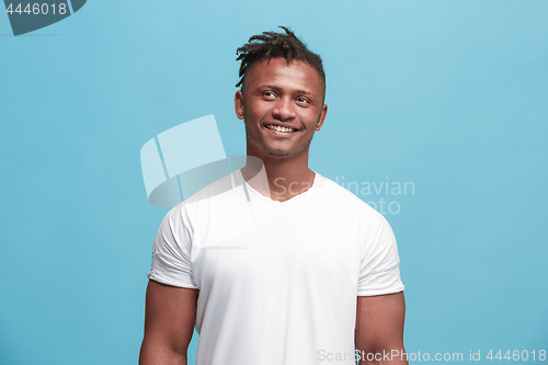 Image of The happy afro-american business man standing and smiling against blue background.