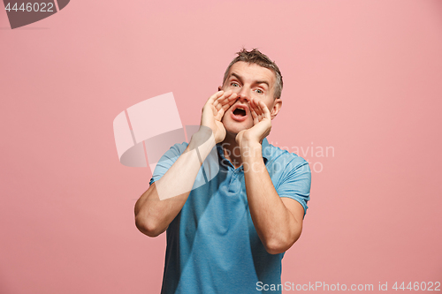 Image of Isolated on pink young casual man shouting at studio