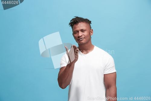 Image of Portrait of attractive Afro-American man with air kiss isolated over blue background