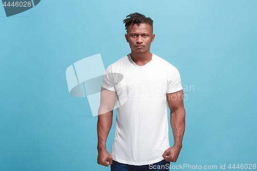 Image of The young emotional angry afro man on blue studio background