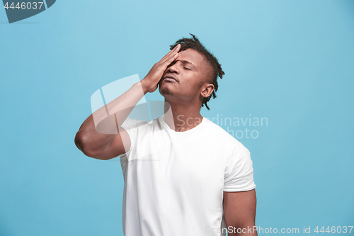 Image of African American Man having headache. Isolated over blue background.