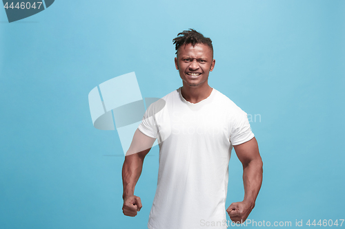 Image of The young emotional angry afro man screaming on blue studio background