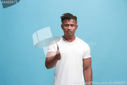 Image of The overbearing afro-american businessman point you and want you, half length closeup portrait on blue background.