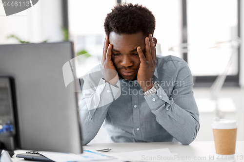 Image of stressed businessman with papers at office