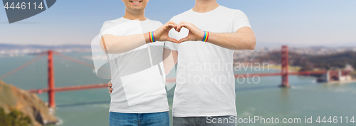 Image of couple with gay pride rainbow wristbands and heart