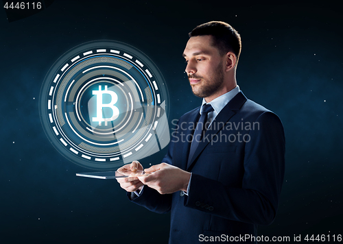 Image of businessman with tablet pc and bitcoin hologram