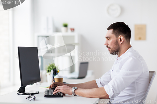 Image of businessman typing on computer keyboard at office