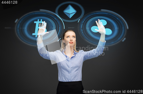 Image of businesswoman with cryptocurrency holograms