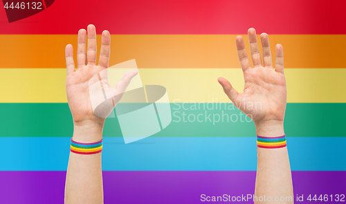 Image of hands with gay pride rainbow wristbands