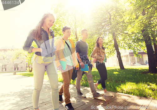 Image of group of happy teenage students walking outdoors