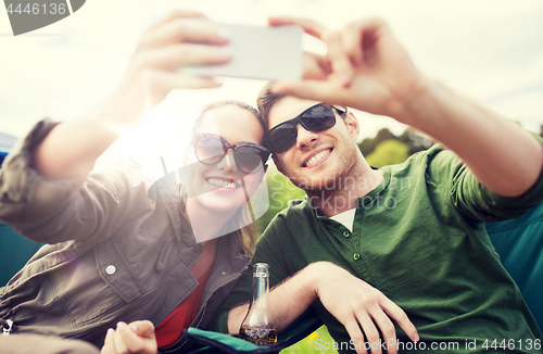 Image of couple of travelers taking selfie by smartphone