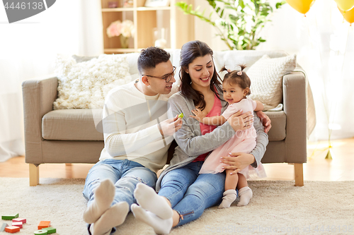 Image of baby girl with parents at home