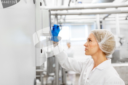 Image of woman programming computer at ice cream factory