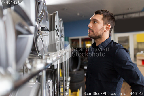 Image of male customer choosing wheel rims at car service