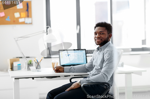 Image of african american businessman with pen at office