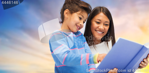 Image of happy mother and daughter reading book over sky