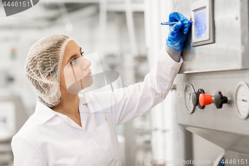 Image of woman programming computer at ice cream factory