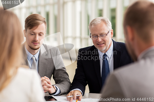 Image of smiling business people meeting in office