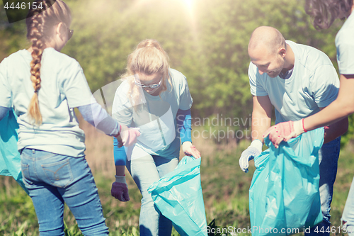 Image of volunteers with garbage bags cleaning park area