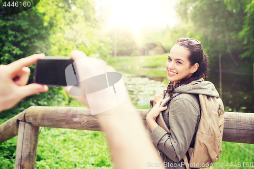 Image of couple with backpacks taking picture by smartphone