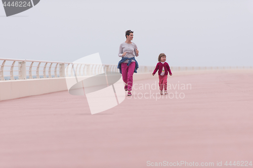 Image of mother and cute little girl on the promenade by the sea