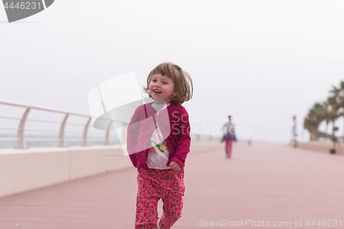 Image of mother and cute little girl on the promenade by the sea