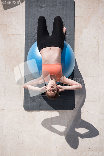 Image of woman doing exercise with pilates ball top view