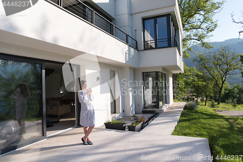 Image of woman in a bathrobe enjoying morning coffee