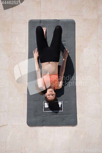 Image of woman doing morning yoga exercises top view