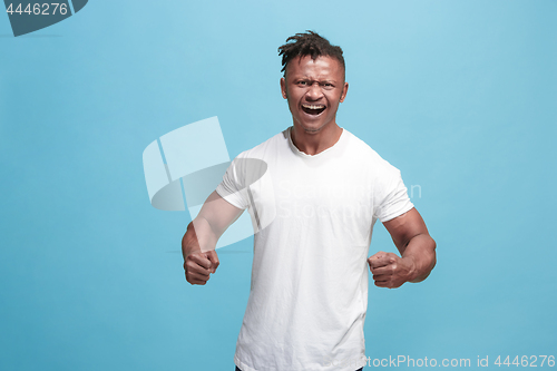 Image of The young emotional angry afro man screaming on blue studio background