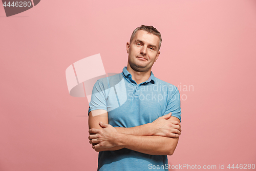 Image of The happy business man standing and smiling against pink background.