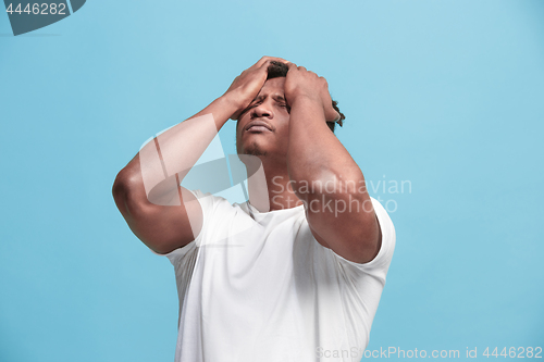 Image of African American Man having headache. Isolated over blue background.