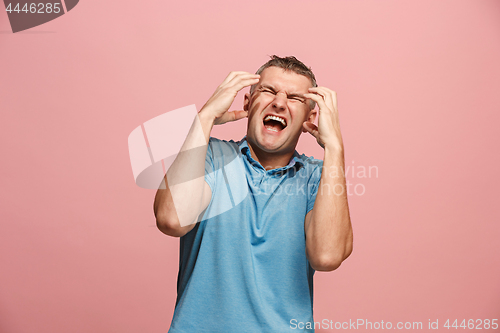 Image of The young emotional angry man screaming on pink studio background