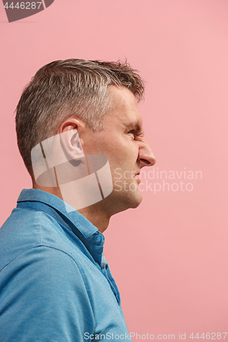 Image of The young emotional angry man screaming on pink studio background