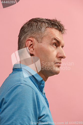 Image of Suspiciont. Doubtful pensive man with thoughtful expression making choice against pink background