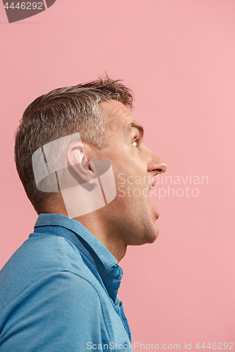 Image of The young emotional angry man screaming on pink studio background