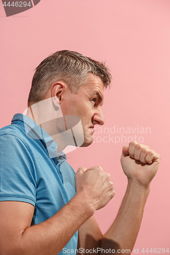 Image of The young emotional angry man screaming on pink studio background