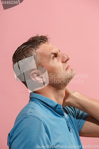 Image of Young man overwhelmed with a pain in the neck .